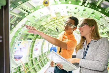 Two individuals discussing a project inside an aircraft fuselage